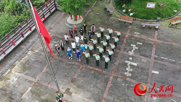 北川中队的官兵与村民们一起升起鲜艳的五星红旗，共同庆祝中华人民共和国成立75周年。杨松岗 摄