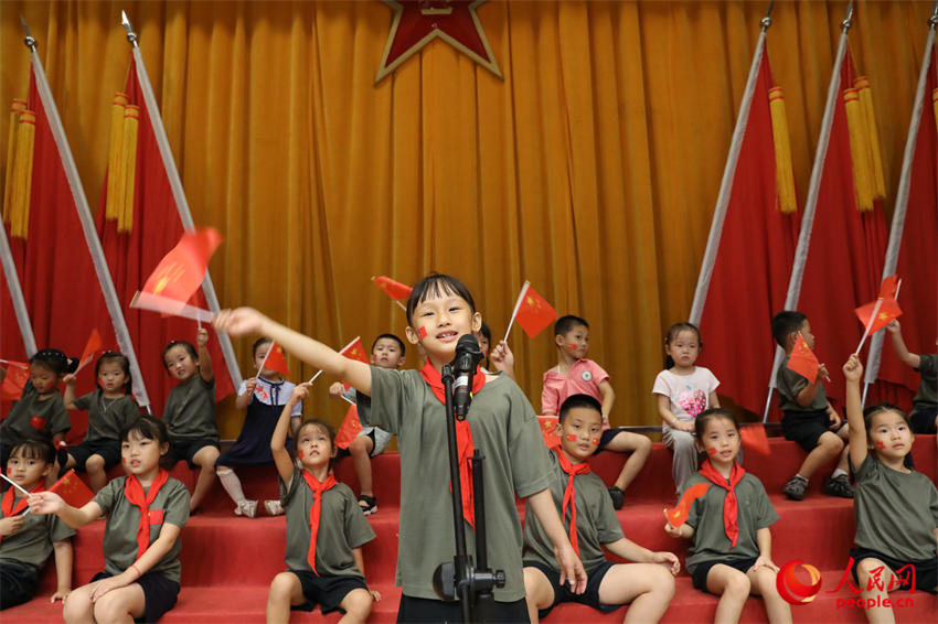 组织军娃与国旗合影，培塑蓝天娃爱国情怀。