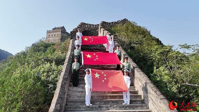 巍巍长城上，边海防官兵展开来自高原和海岛的国旗。贾思宇 摄