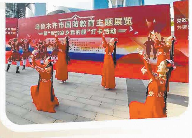新疆乌鲁木齐市国防教育主题展览上，维吾尔族群众表演民族歌舞。党文彬摄