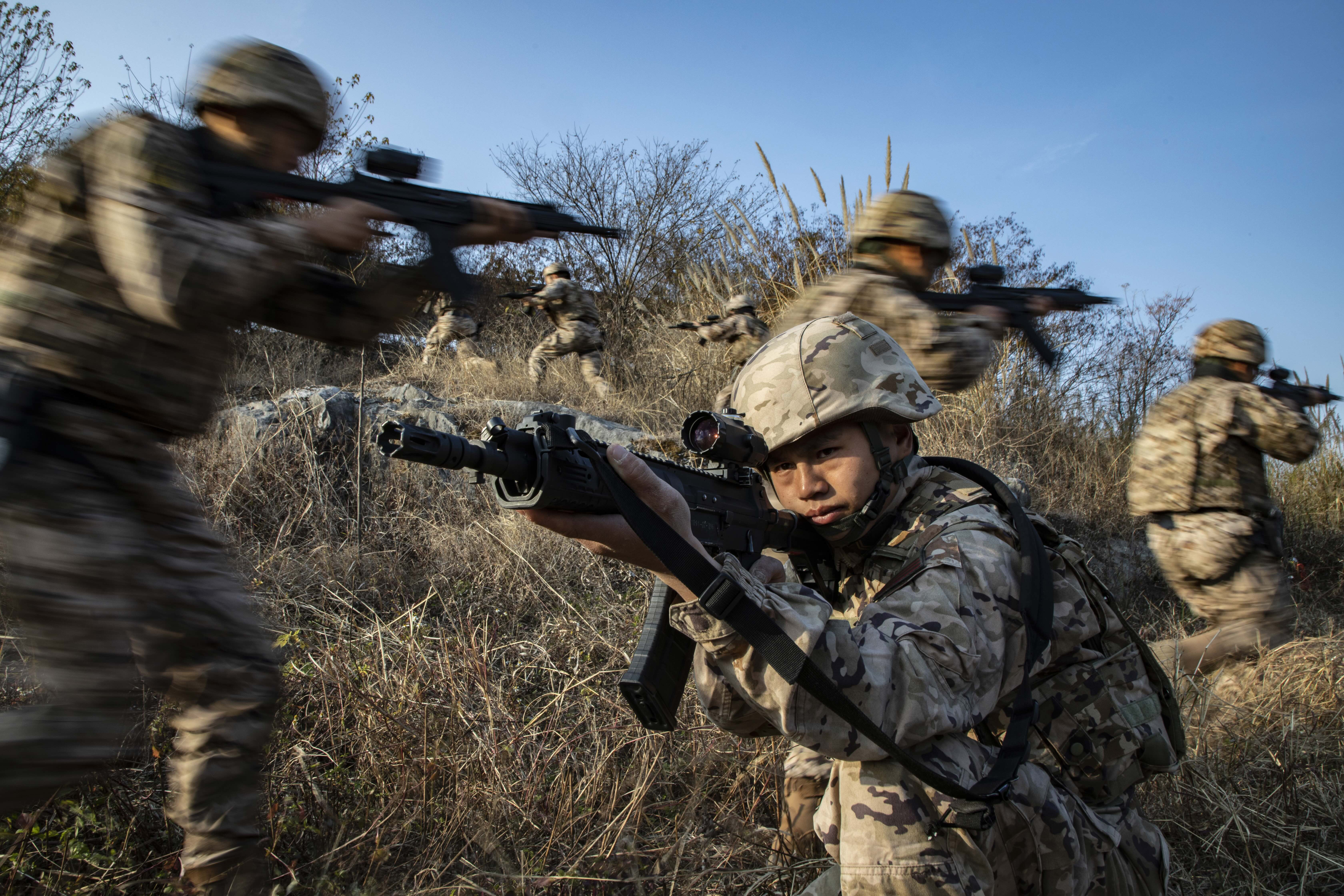 图为武警官兵掩护队友搜索目标。施晨洲 摄