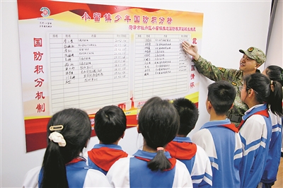 在小留镇党群服务中心，牡丹区人武部工作人员介绍“少年国防积分”榜上学生积分情况。刘继璐摄