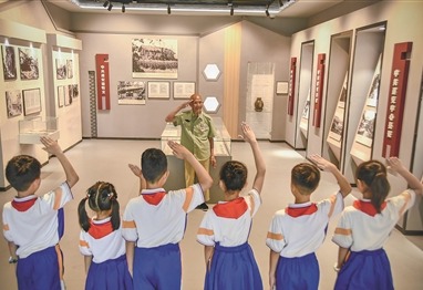 岳石小学学生向抗战老兵吴绍卿行少先队队礼。贾祥龙摄