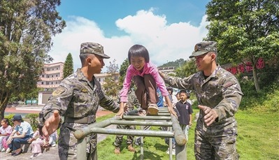佳克学校学生在武警官兵的保护下,开展军事项目体验。李梓良摄