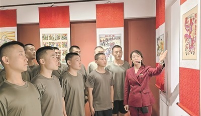 武强县年画博物馆工作人员为预定新兵讲述抗战年画背后的创作故事。夏洪涛 摄