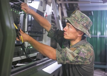 信息支援部队某旅军士丁浩在演训任务中调试装备。李伯康摄