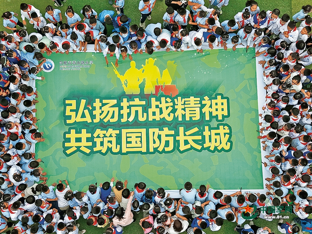 安徽省合肥市蜀山区人武部联合当地学校开展国防教育进校园活动。图为学生们在国防教育主题海报上签名。葛宜年摄