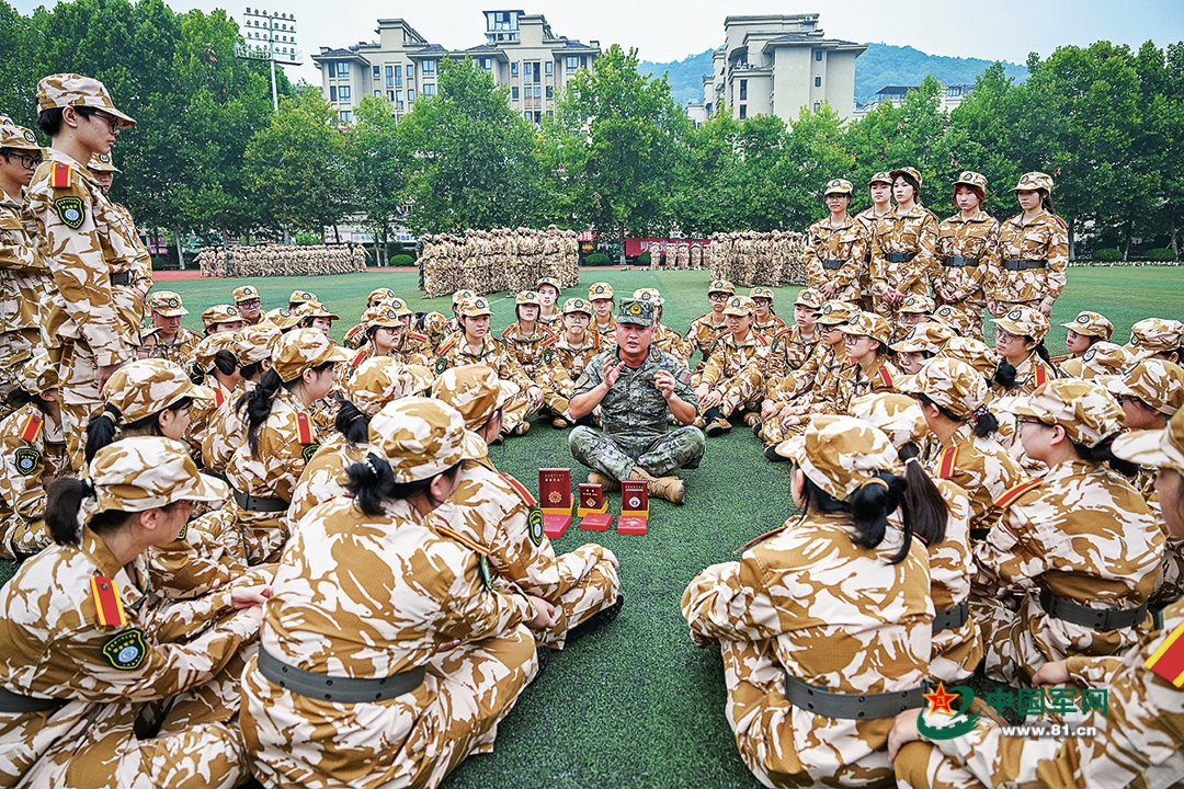 武警重庆总队机动支队为驻地高校开展军训时,穿插组织国防教育活动。图为一级上士安俊吉为学生们讲述所获奖章、纪念章背后的故事。本报特约通讯员  王  肸摄