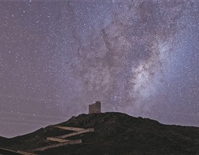 一名战士拍摄星空下的戈壁哨楼。