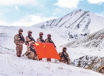 抵达目的地后，巡逻官兵与国旗合影。