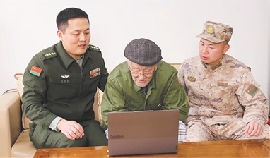 图①：路晨（中）在佟指导员（左）陪伴下与官兵视频连线。