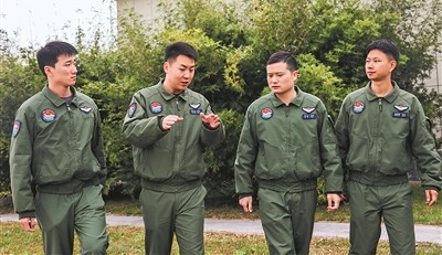 一位副政治教导员（左二）与飞行员交流谈心。李希鑫、兰尔文摄