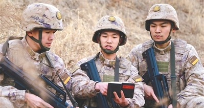 何加伟（中）利用《战斗日志》与战友探讨战术。孙梓菡摄