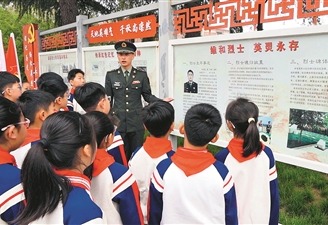 “申亮亮班”第3任班长汤宏华正在给前来烈士陵园祭扫的温县城内小学的学生们讲述“人民英雄”申亮亮的事迹。本报记者  汪  飞摄