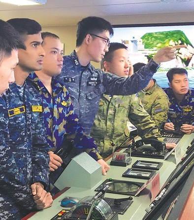 外国军官和中方学员在模拟驾驶室共同完成舰艇靠泊训练。本报记者　张　丹摄