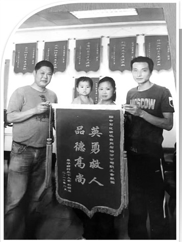 2010年，郑妍一家给余献国（左一）送来锦旗表达谢意。