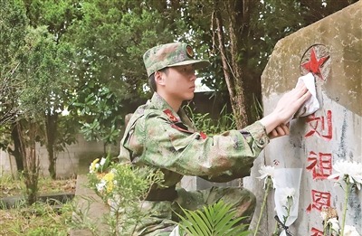 贵州省铜仁军分区组织民兵擦拭烈士墓碑。严  鹏摄