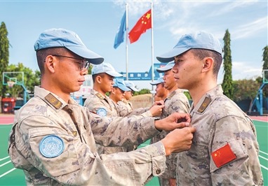 中国第12批赴南苏丹（朱巴）维和步兵营老党员为新党员佩戴党员徽章。王利国摄